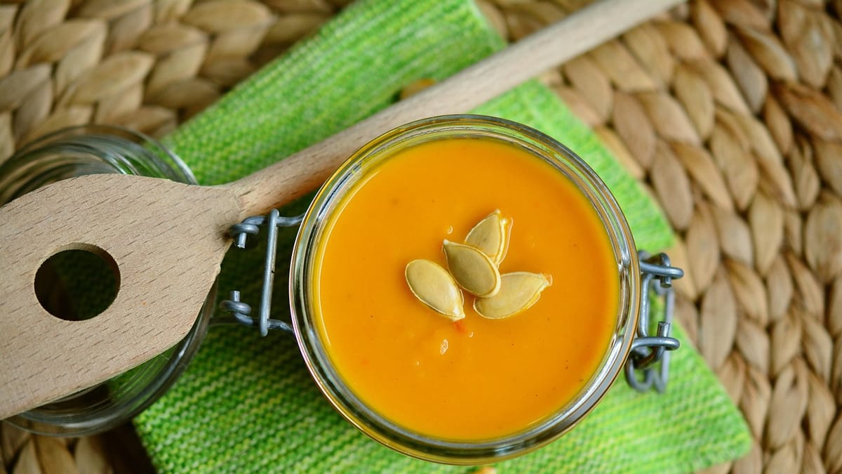 Velouté orange conservé dans un bocal en verre fermé, avec une cuillère en bois