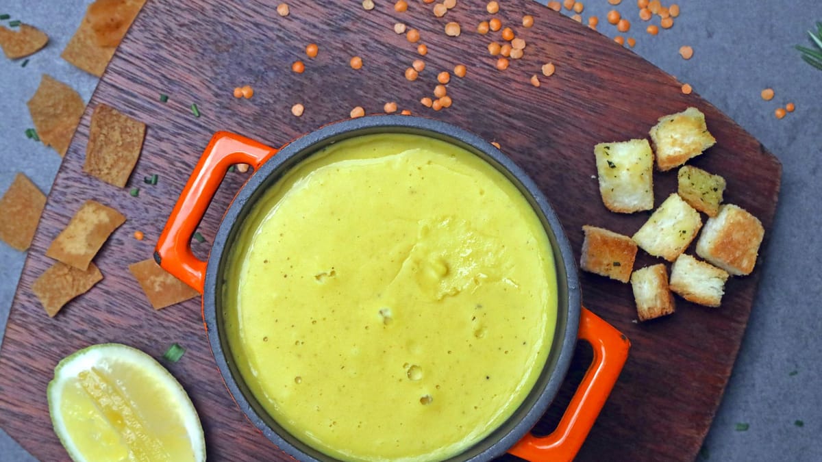 Velouté bien lisse dans une petite cocotte orange, avec des croûtons et un citron