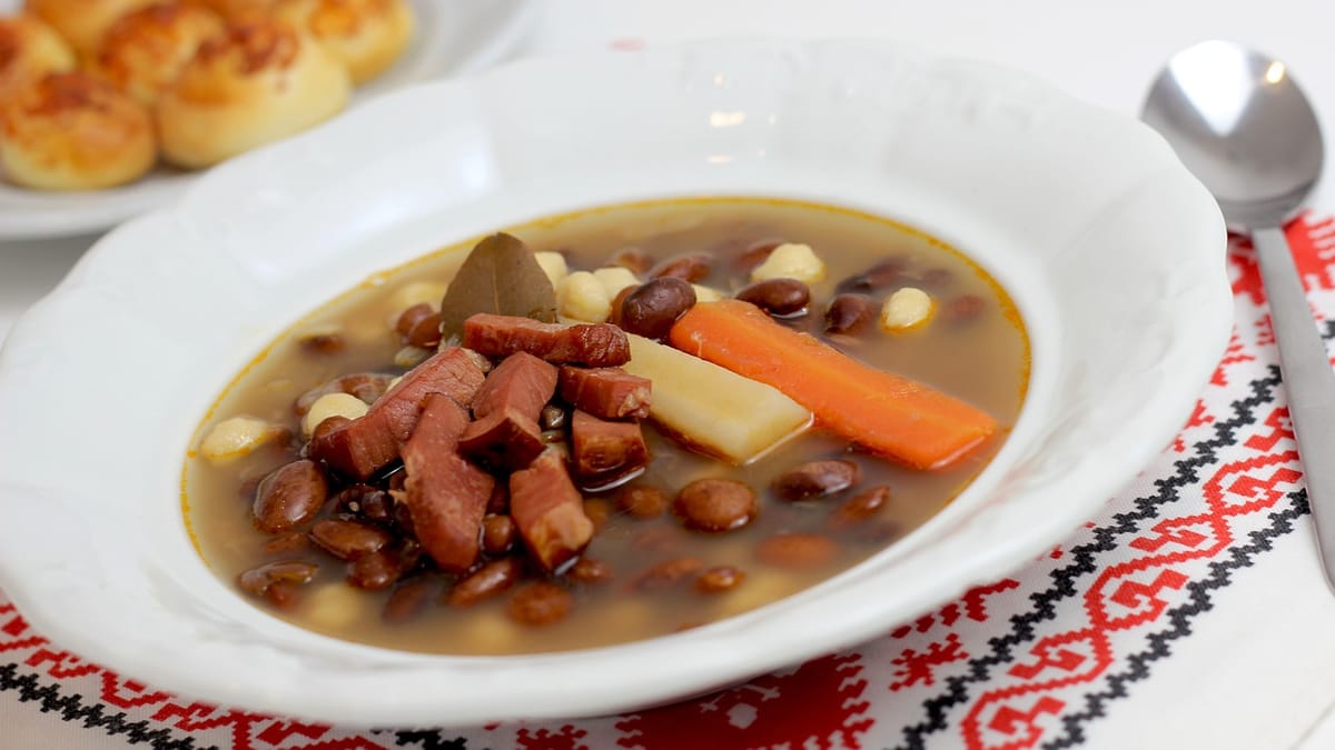 Assiette de soupe paysanne aux haricots, morceaux de lard et carottes