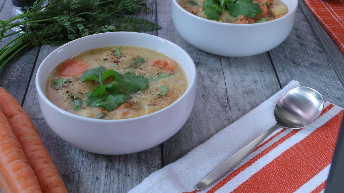 Deux bols de soupe de légumes aux carottes sur une table en bois